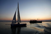 Egyszem�lyes balatoni vitorl�sverseny r�sztvev�je s�t�ted�s el�tt a Balatonon. [133225]